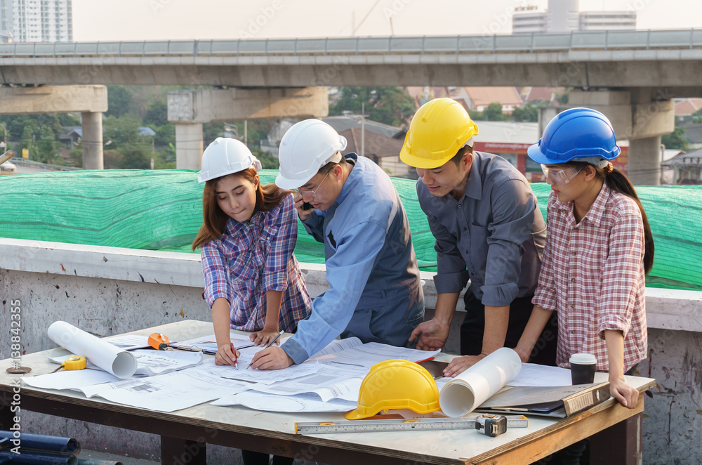business people group on meeting and presentation with construction engineer architect and worker looking building model and blueprint plans