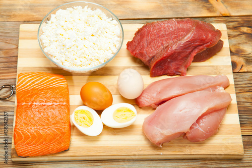 Obraz na plátně Protein diet, fish, cheese, eggs, meat and chicken on a wooden background
