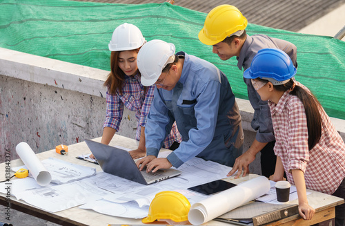 business people group on meeting and presentation with construction engineer architect and worker looking building model and blueprint plans