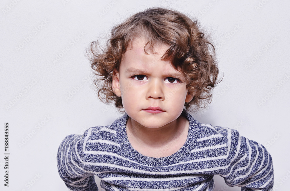 Beautiful angry boy looking at you. Mad kid got upset and sad and he has a negative attitude. Depressed boy complaining Beautiful angry boy looking at you. Mad kid got upset and sad and he has a negative attitude. Depressed boy complaining