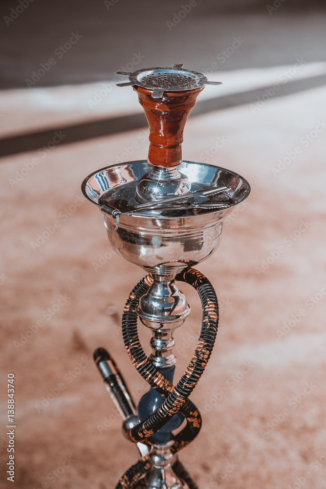 Big hookah for tobacco made of metal, glass and ceramics. Shine. Sunny day  Stock Photo