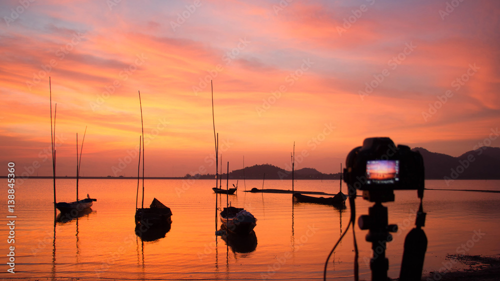Fototapeta premium Camera standing on tripod at sunset at the sea in Thailand; landscape