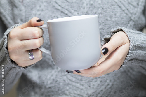 Grey cup in female hands photo