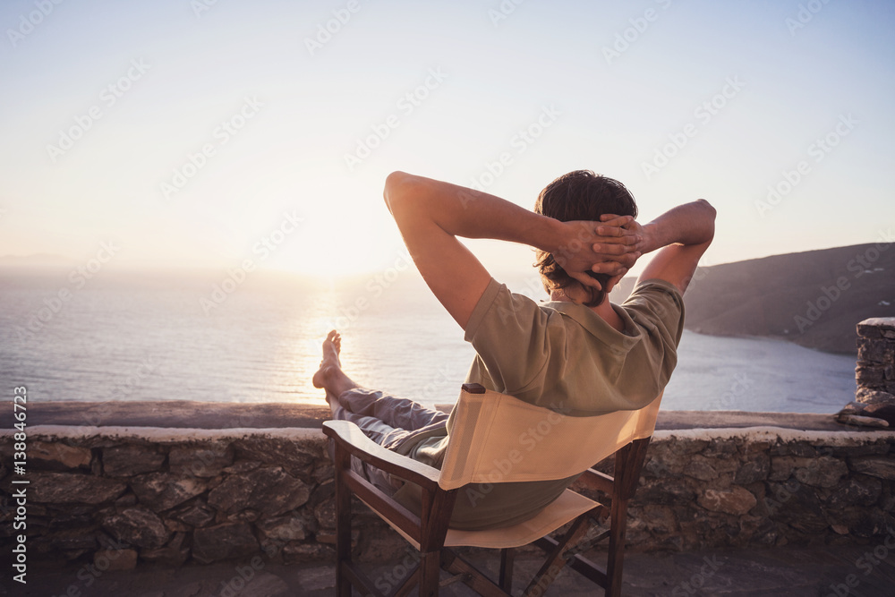 Enjoying life. Back side of young man looking at the sea, vacations  lifestyle, mindfulness, summer fun concept Stock Photo