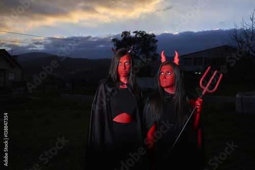 Dos mujeres jóvenes disfrazadas de demonio en Halloween photo