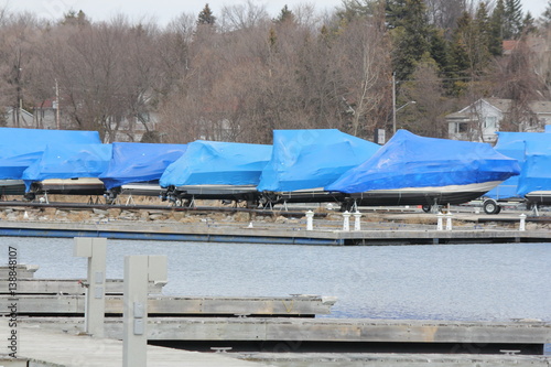 Blue shrink wrap on boats covered in during the winter season as protection against elements.