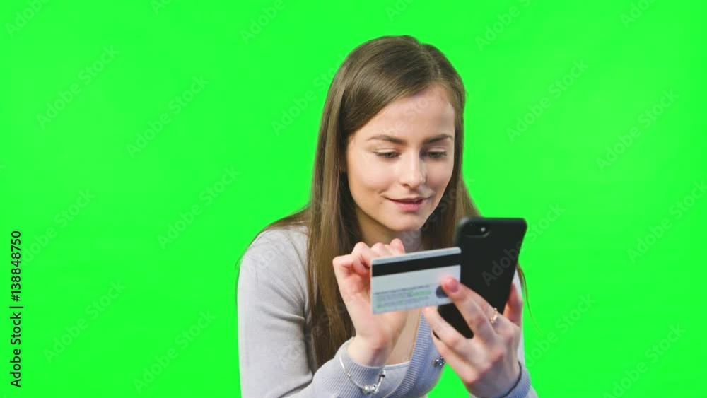 Young woman online shoping with bank cards a phone on green screen background. Young woman online shoping with bank cards a phone on green screen background.