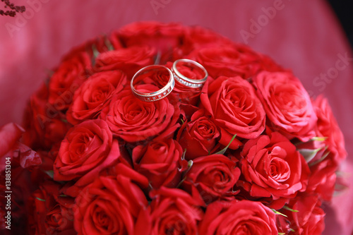 gold wedding rings newlyweds decorated in bright red bouquet of real roses