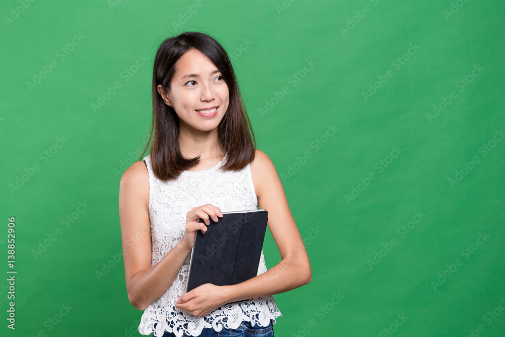 Woman holding tablet computer and looking far away Woman holding tablet computer and looking far away