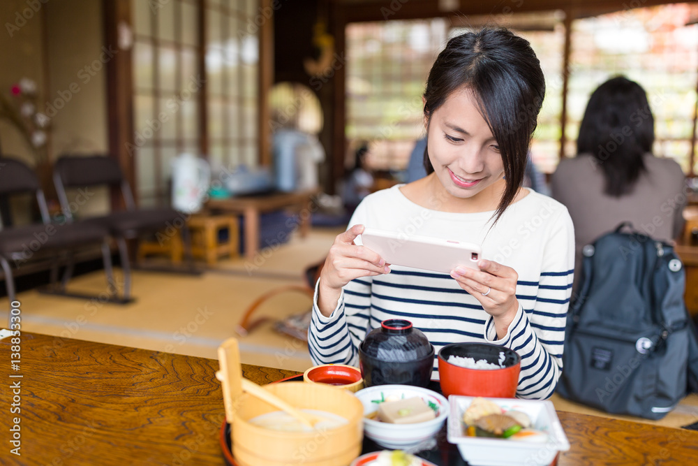 Woman taking photo with cellphone on her meal Woman taking photo with cellphone on her meal
