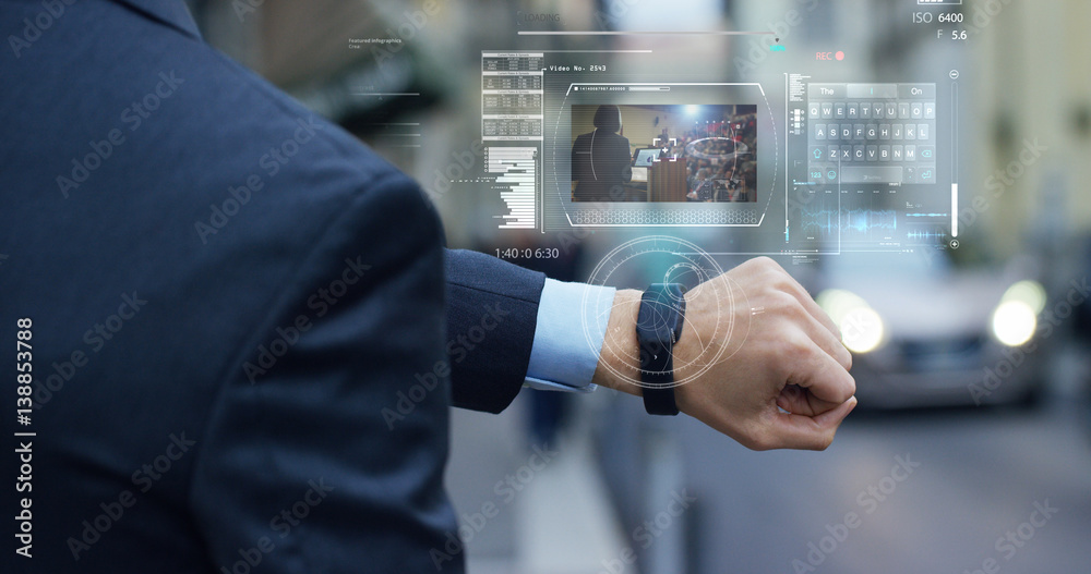 A businessman is followed by a conference on the economy and finance that appears in hologram clock futuristic and technological. Concept: network, conference, technology, augmented reality and future A businessman is followed by a conference on the economy and finance that appears in hologram clock futuristic and technological. Concept: network, conference, technology, augmented reality and future