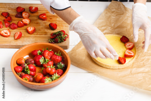 decorating fresh strawberry tart photo