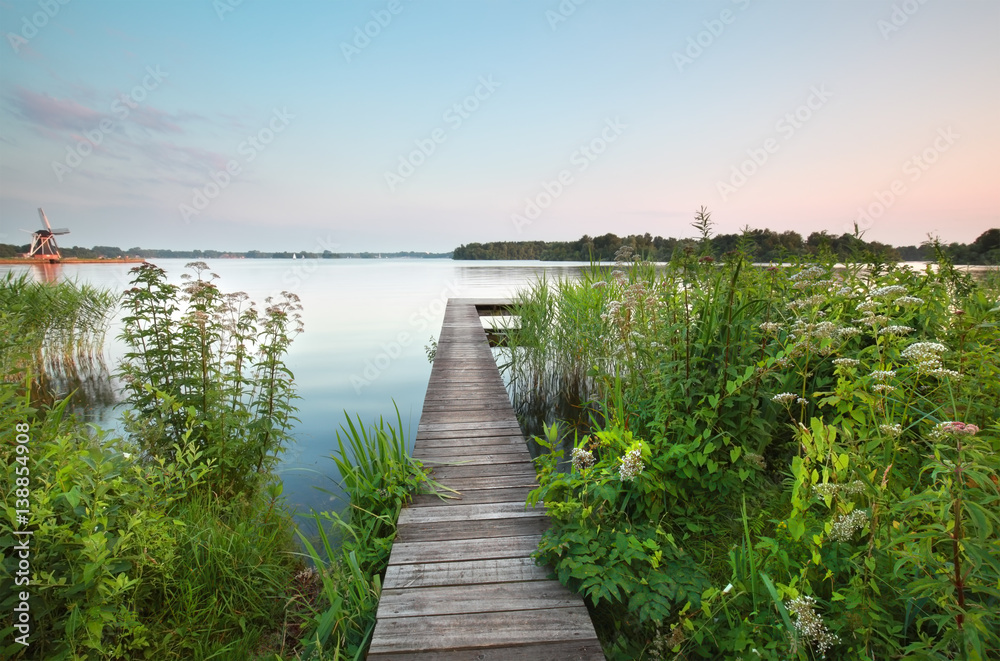 Fototapeta premium pier on big lake and wildflowers
