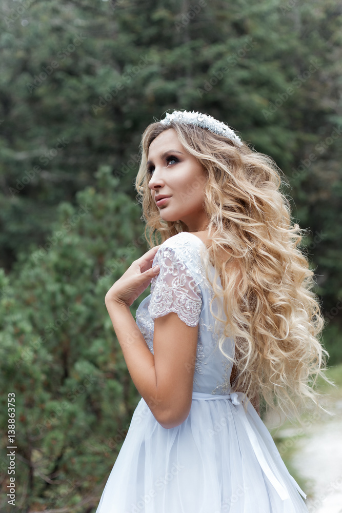 beautiful gentle girl bride in the air fairy blue wedding dress with luxurious curls in the mountains near the lake with a crown utterly beautiful gentle girl bride in the air fairy blue wedding dress with luxurious curls in the mountains near the lake with a crown utterly