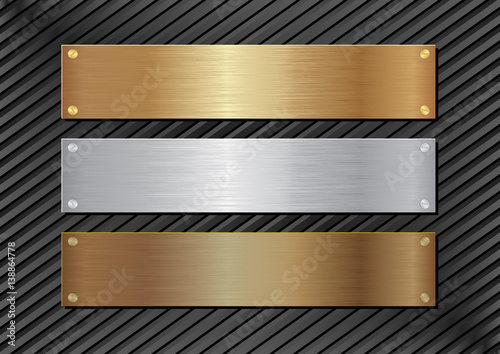 three metal plaques on black background photo