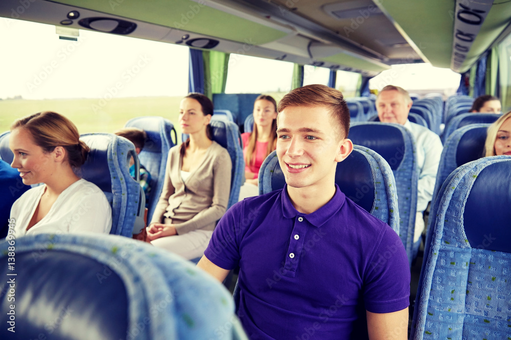 happy young man sitting in travel bus or train