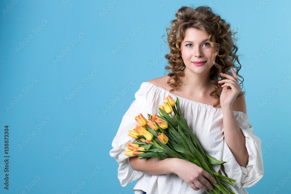 Lovely woman with a bouquet of yellow tulips.