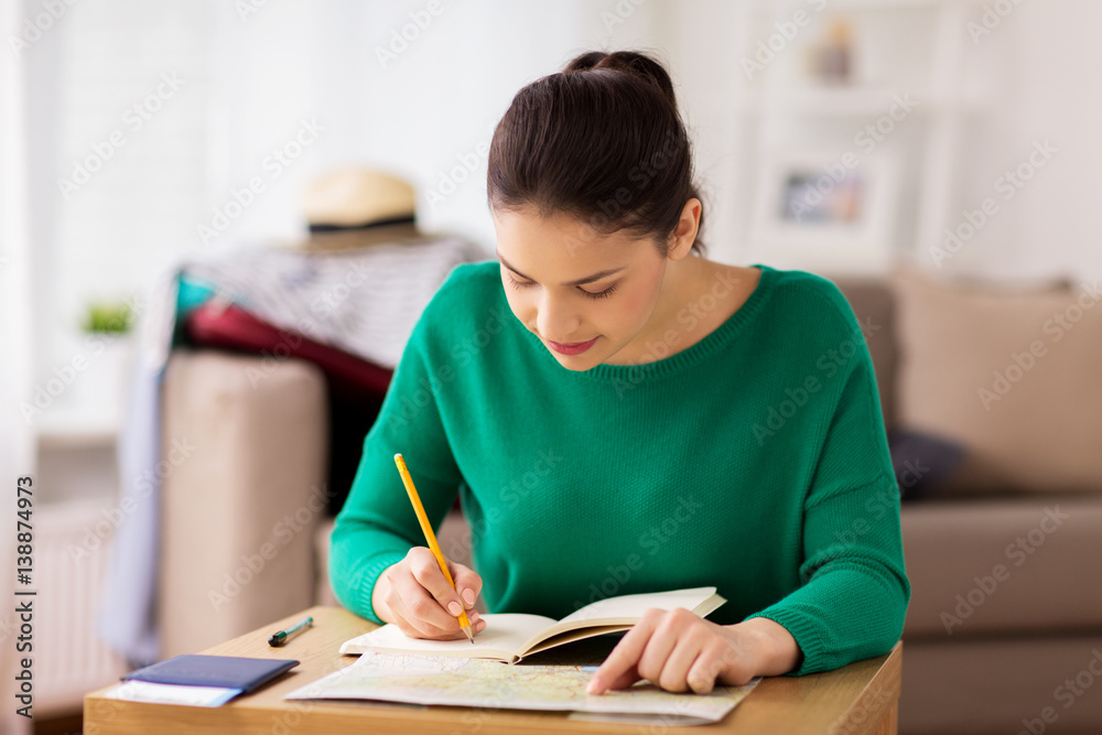 woman with notebook and travel map at home woman with notebook and travel map at home
