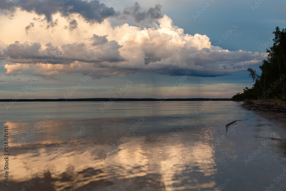 Fototapeta premium Beautiful sunset on the lake, the clouds reflected in the water. Surface on the lake. Russia, Karelia. Wide photo