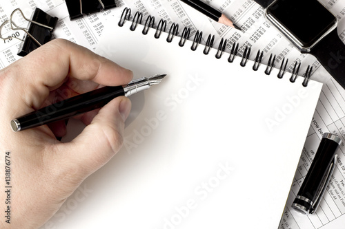 fountain pen in his hand, a white notebook