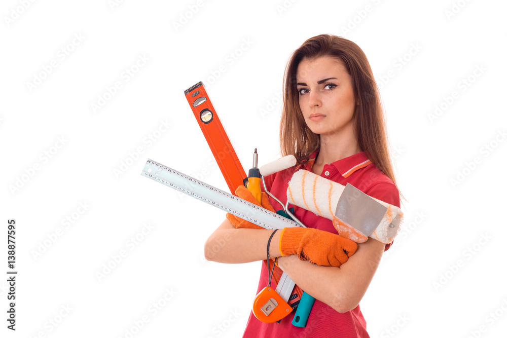 young serious woman with dark hair in uniforl makes renovations with tools in her hands isolated on white background young serious woman with dark hair in uniforl makes renovations with tools in her hands isolated on white background