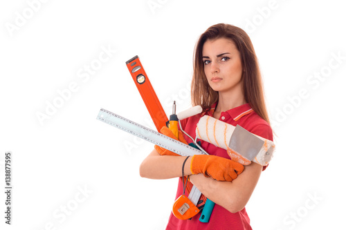 young serious woman with dark hair in uniforl makes renovations with tools in her hands isolated on white background