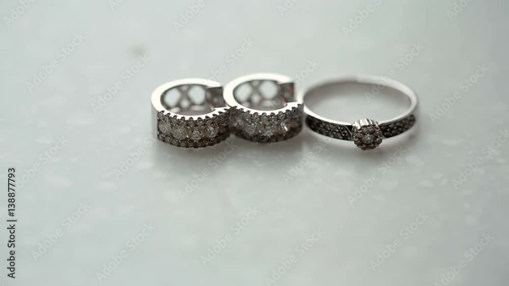 Golden ring and earrings with diamonds on white background Golden ring and earrings with diamonds on white background