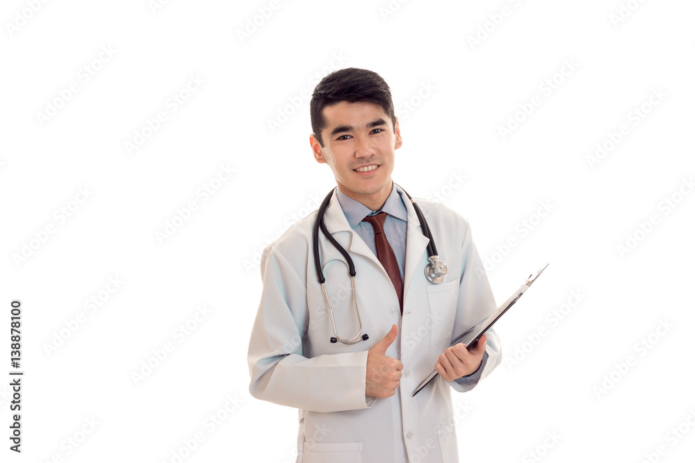 young beautiful doctor in blue uniform with stethoscope on his neck make notes and smiles isolated on white background young beautiful doctor in blue uniform with stethoscope on his neck make notes and smiles isolated on white background