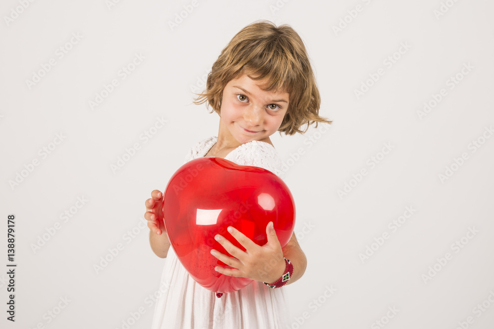 kid playing with a red balloon in the studio. Fun, lifestyle, white background kid playing with a red balloon in the studio. Fun, lifestyle, white background