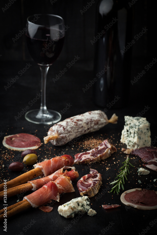 Salami, prosciutto, cheese, cured meat, rosemary and a glass of wine