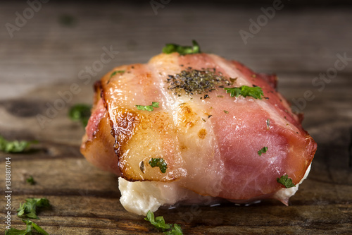 Close up of fried goat cheese wrapped in smoked bacon on wood photo