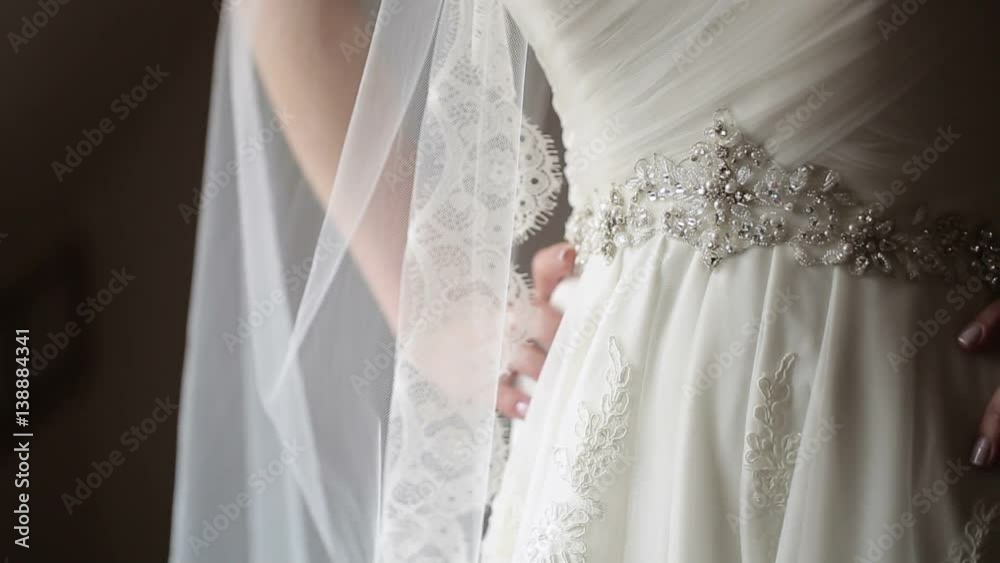 Unrecognizable bride staying near window in wedding dress Unrecognizable bride staying near window in wedding dress