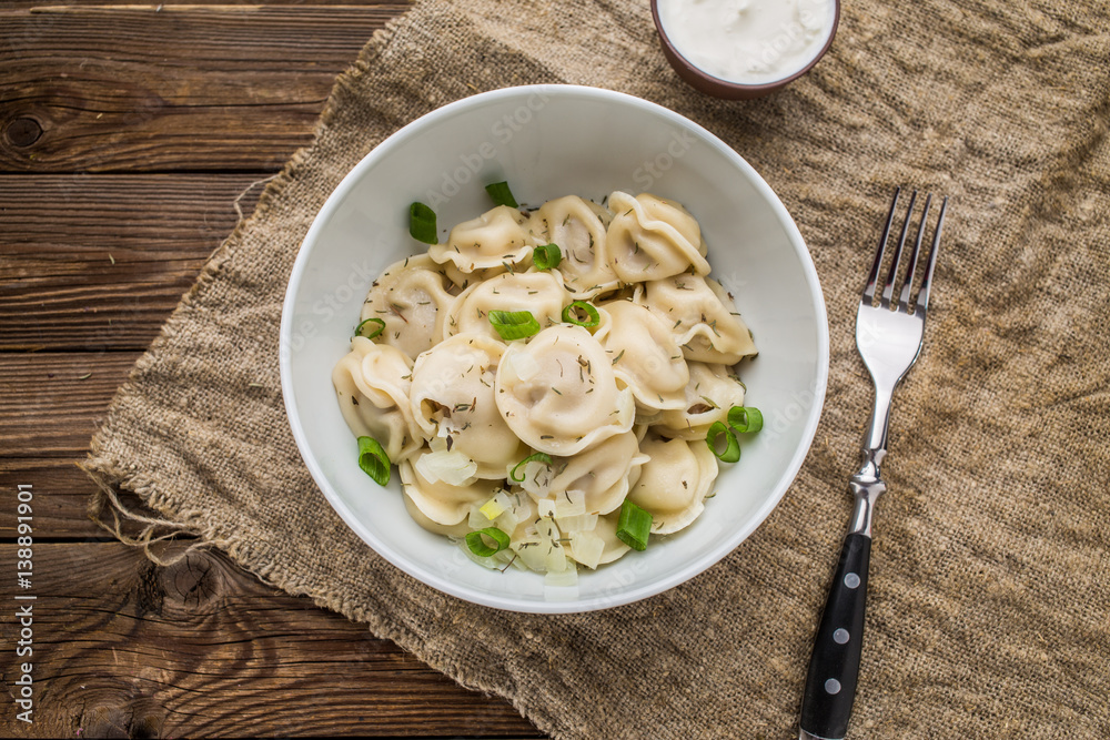 Meat dumplings - russian pelmeni, ravioli with meat on a white plate Meat dumplings - russian pelmeni, ravioli with meat on a white plate