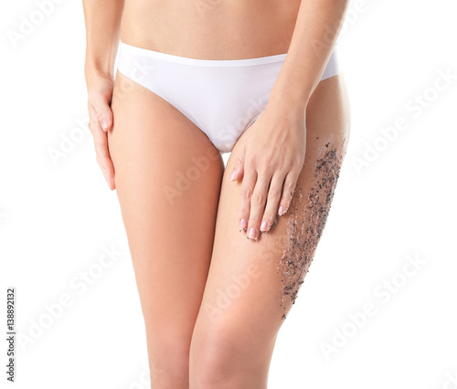 Young woman applying natural scrub on body, closeup