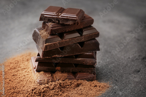 Chocolate with cocoa powder on grey background