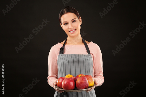 Young woman in apron holdin...