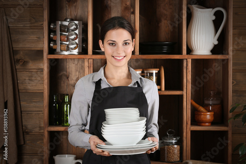 Woman holding pile of table...