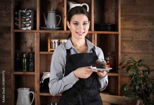 Woman in apron holding plat...