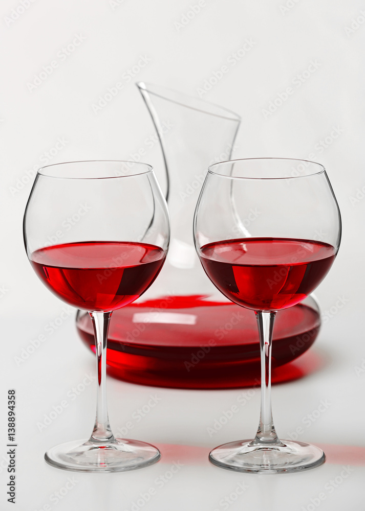 Red wine in glasses and decanter on white background