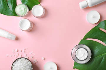 Natural cosmetics and leaves on pink background