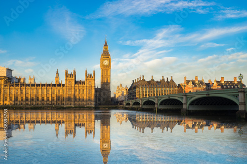 Big Ben and Westminster parliament with blue sky and water reflection in London, UK photo