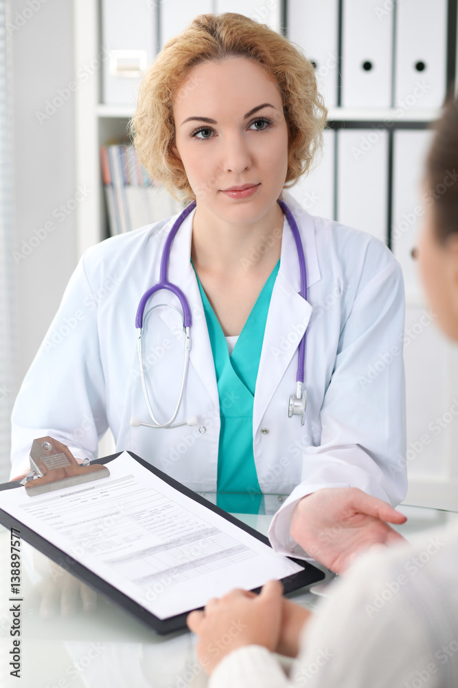Happy blonde female doctor and patient discussing medical examination results. Medicine, healthcare and help concept Happy blonde female doctor and patient discussing medical examination results. Medicine, healthcare and help concept