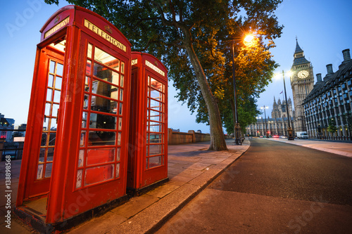 A traditional red phone booth in London with the Big Ben in the background