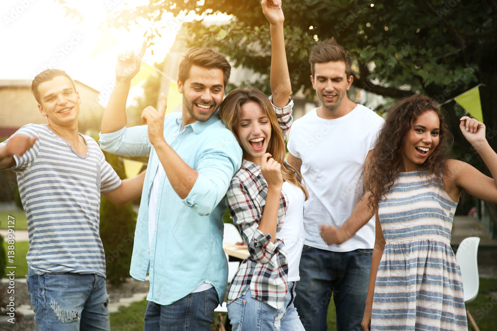 Young friends dancing at party outdoors