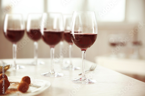 Red wine and delicious chocolate truffles on white table
