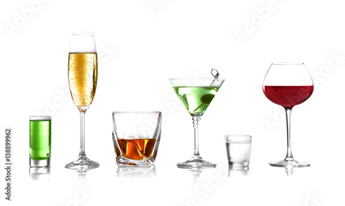 Glasses of wine and spirits on light background