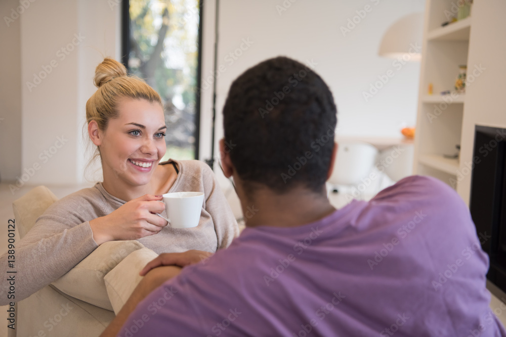 Young multiethnic couple in front of fireplace Young multiethnic couple in front of fireplace
