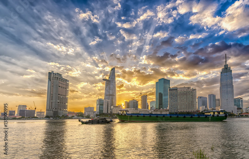 Ho Chi Minh City, Vietnam - February 14th, 2017: Riverside City sunset clouds in the sky at end of day brighter coal sparkling skyscrapers along beautiful river in Ho Chi Minh City, Vietnam © huythoai