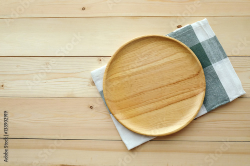 Empty round wooden tray and napkin on table, top view, flat lay, food display montage background with copy space
