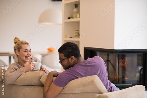 Young multiethnic couple  in front of fireplace